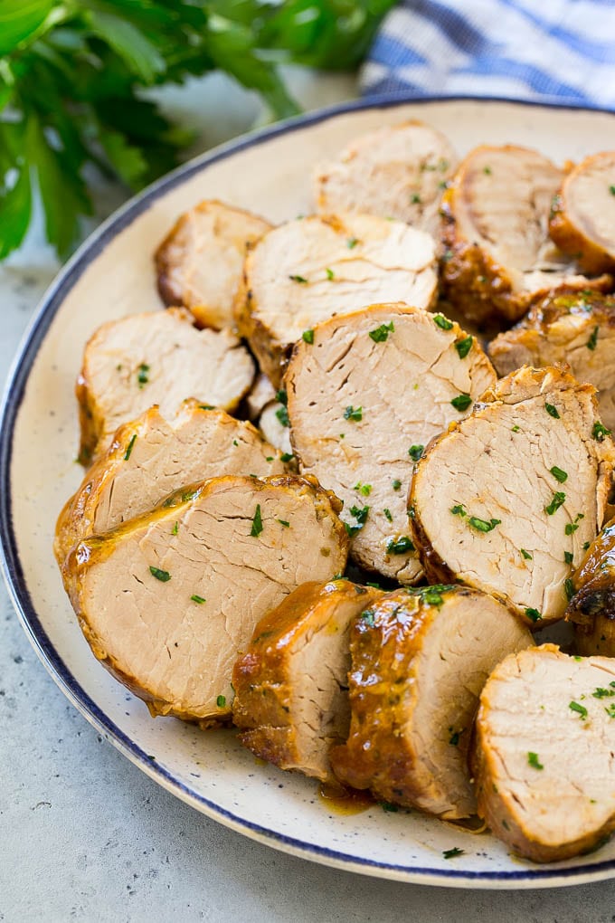 Sliced slow cooker pork tenderloin on a plate.