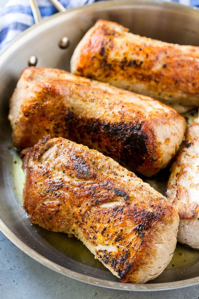 Seared pork tenderloin in a skillet.