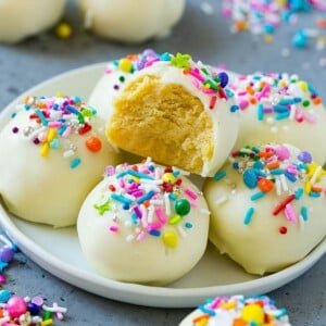 Cake balls on a plate with a bite taken out of one.