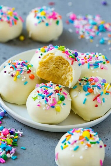 Cake balls on a plate with a bite taken out of one.