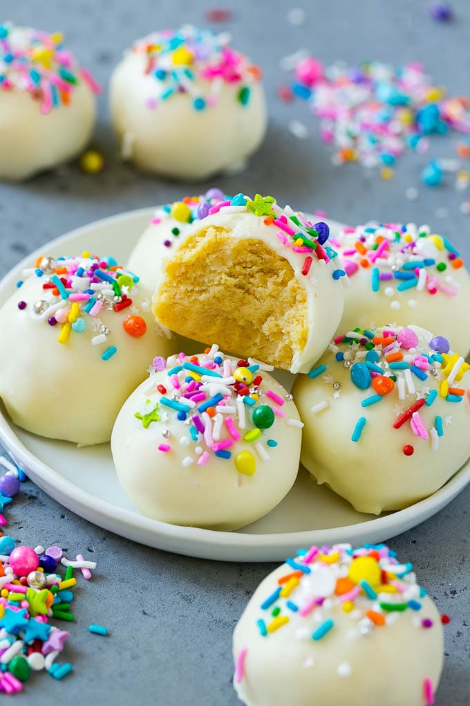 Cake balls on a plate with a bite taken out of one.