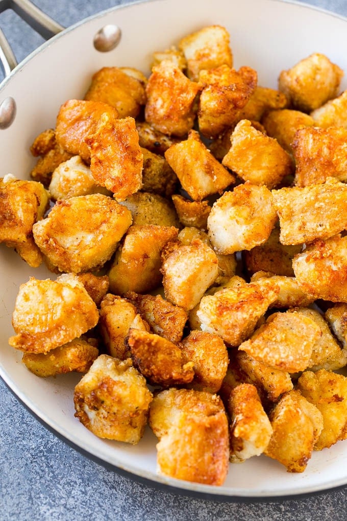 Crispy chicken pieces in a skillet.