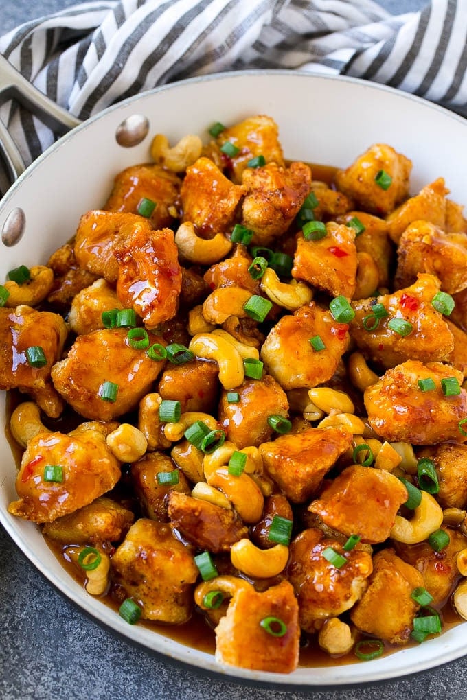 A pan of cashew chicken topped with sliced green onions.