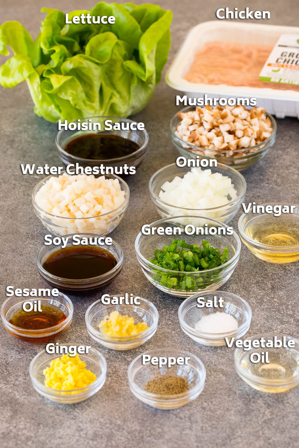 Ingredients including ground chicken, vegetables, seasonings and a head of lettuce.