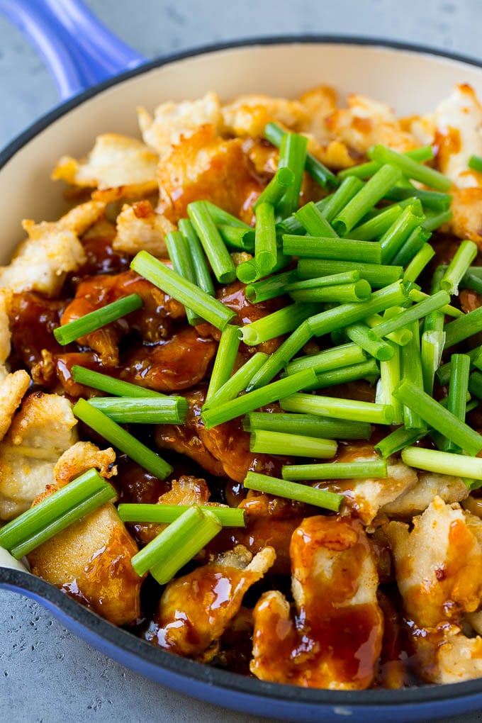 Sliced chicken breast in a skillet with Mongolian sauce and green onions.