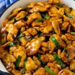 Mongolian chicken with green onions in a skillet.