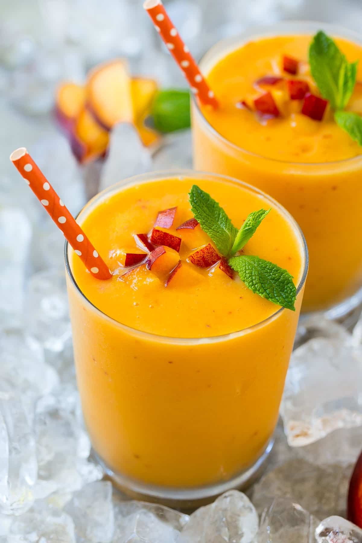 A peach smoothie in ice garnished with mint.