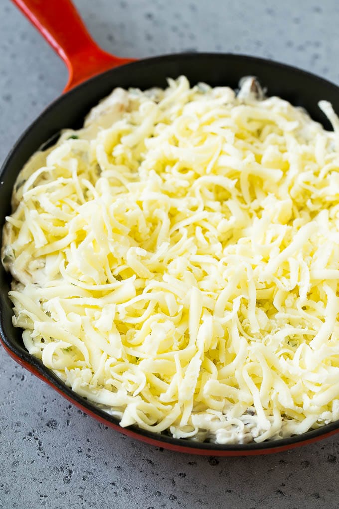 Philly cheesesteak dip with shredded cheese on top, waiting to go into the oven.