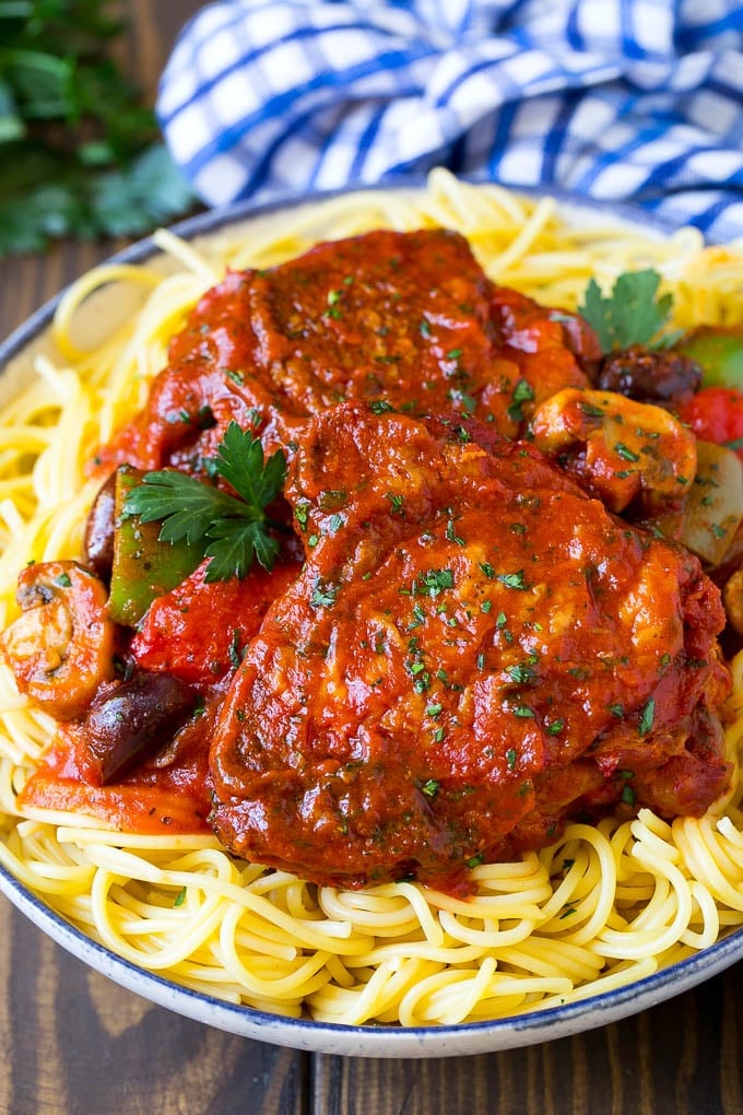 Slow cooker chicken cacciatore served over spaghetti.