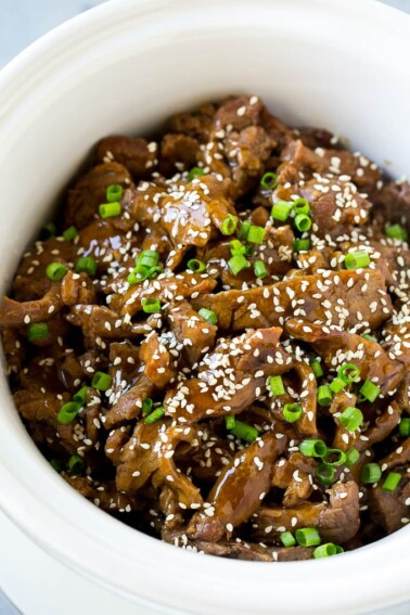 Slow cooker Korean beef with flank steak slices in a sweet and savory sauce, all inside a crock pot.