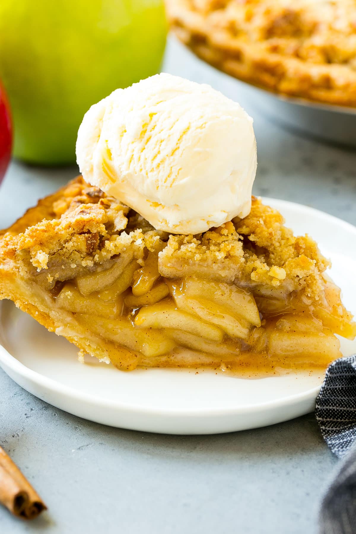 A slice of apple pie topped with ice cream.