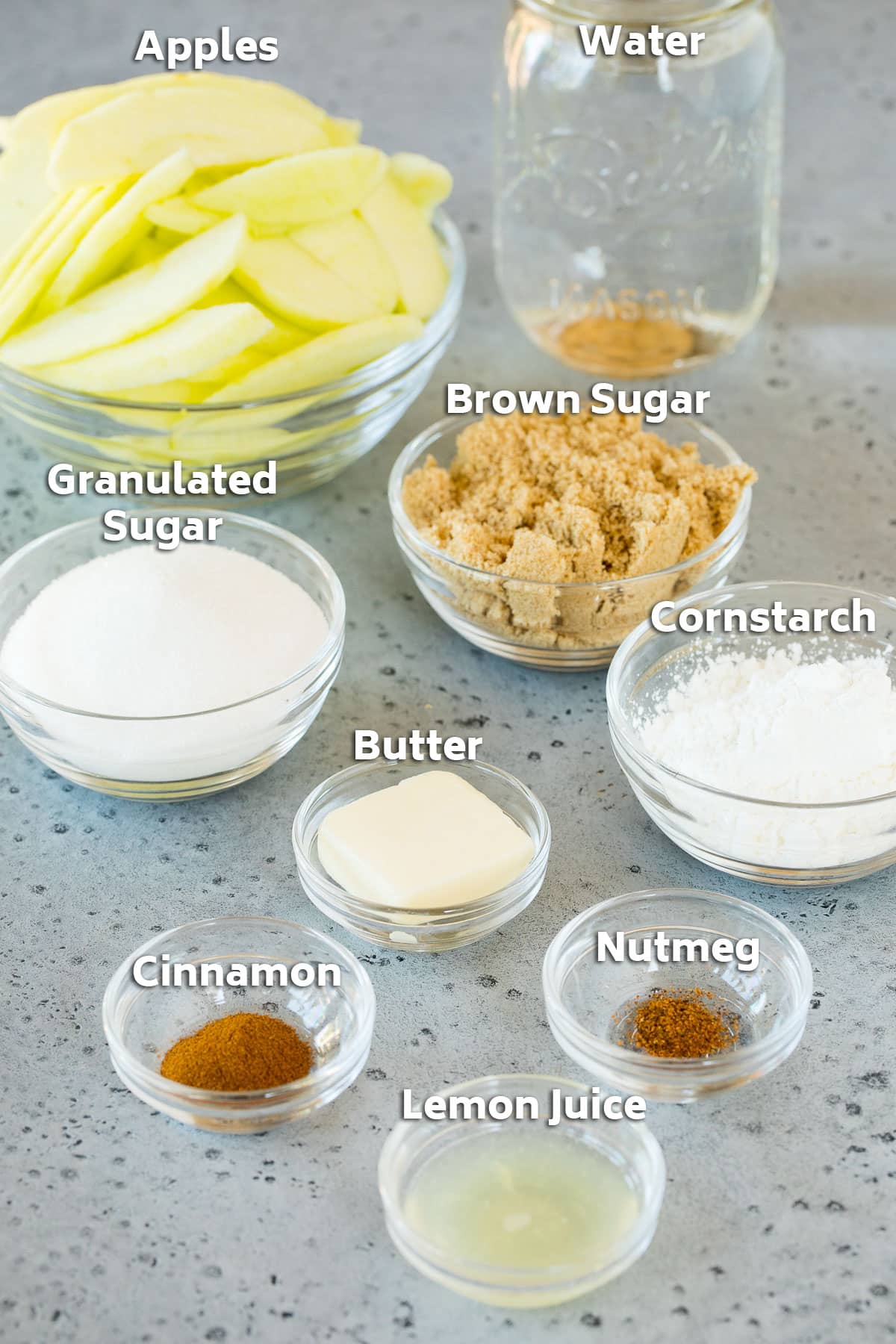 Bowls of ingredients including apples, sugar and spices.