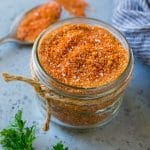A jar of BBQ rub made with brown sugar and a variety of spices.