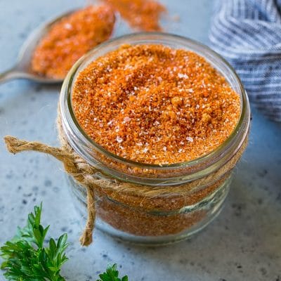 A jar of BBQ rub made with brown sugar and a variety of spices.