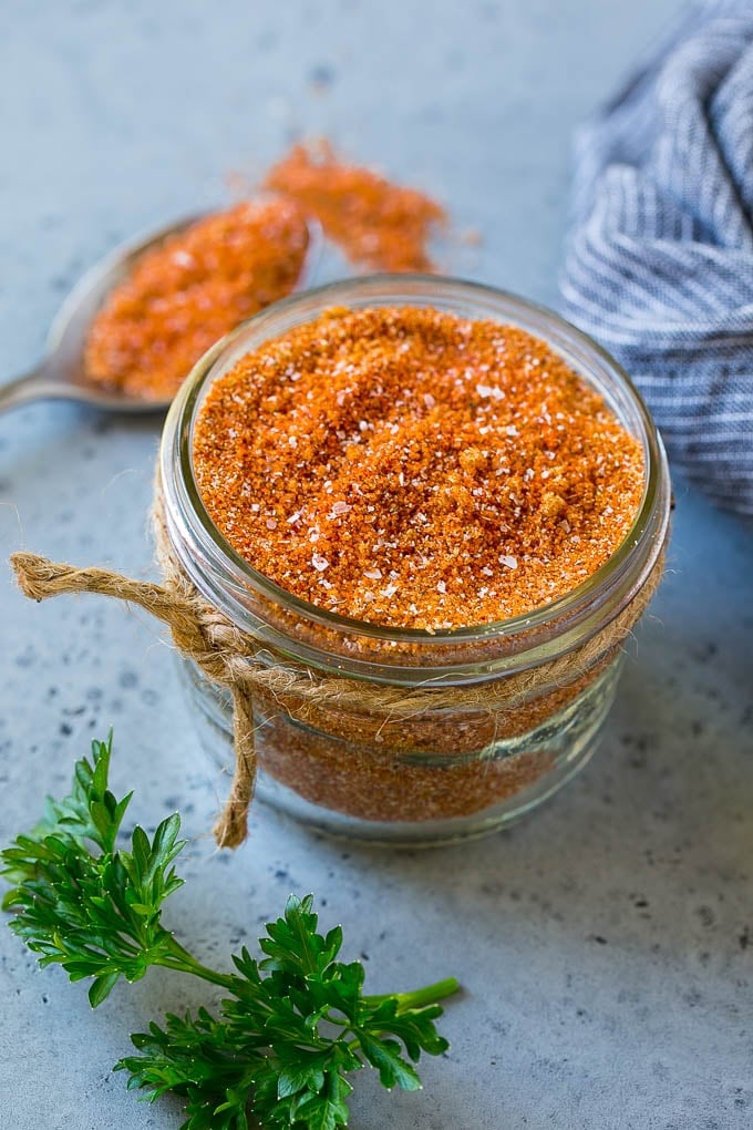 A jar of BBQ rub made with brown sugar and a variety of spices.