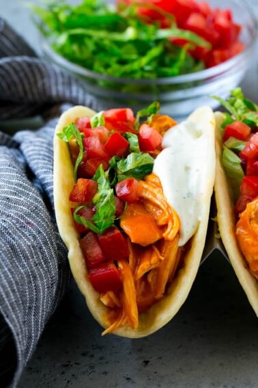 Buffalo chicken tacos with spicy chicken, diced tomato, shredded lettuce and ranch dressing.