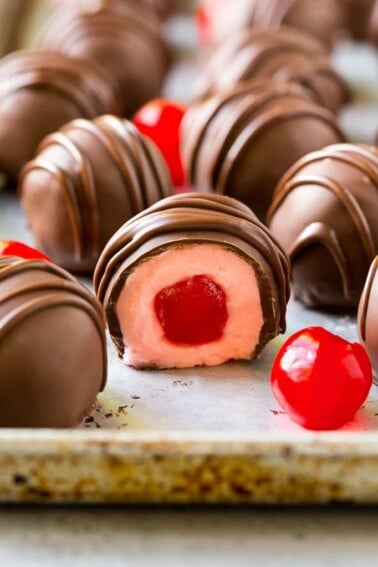 Chocolate covered cherries dipped in dark chocolate with a decorative drizzle.
