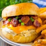 A crack chicken sandwich topped with cheese, bacon and green onions.