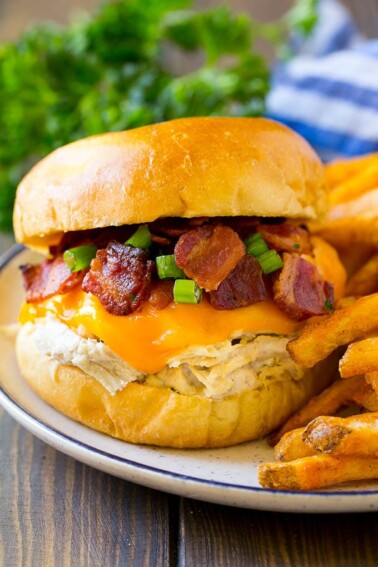 A crack chicken sandwich topped with cheese, bacon and green onions.