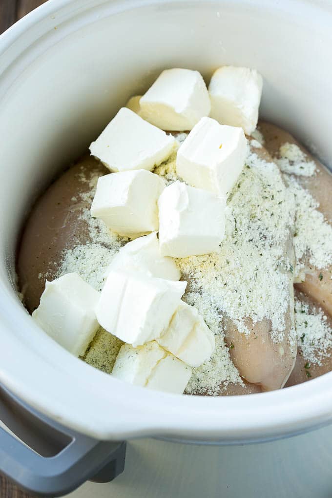 Chicken breasts, cream cheese and ranch powder in the crock pot.