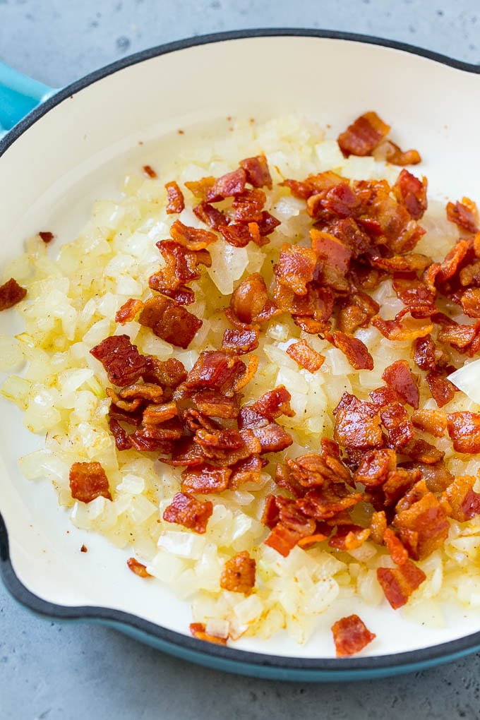 Sauteed bacon and onions in a skillet.