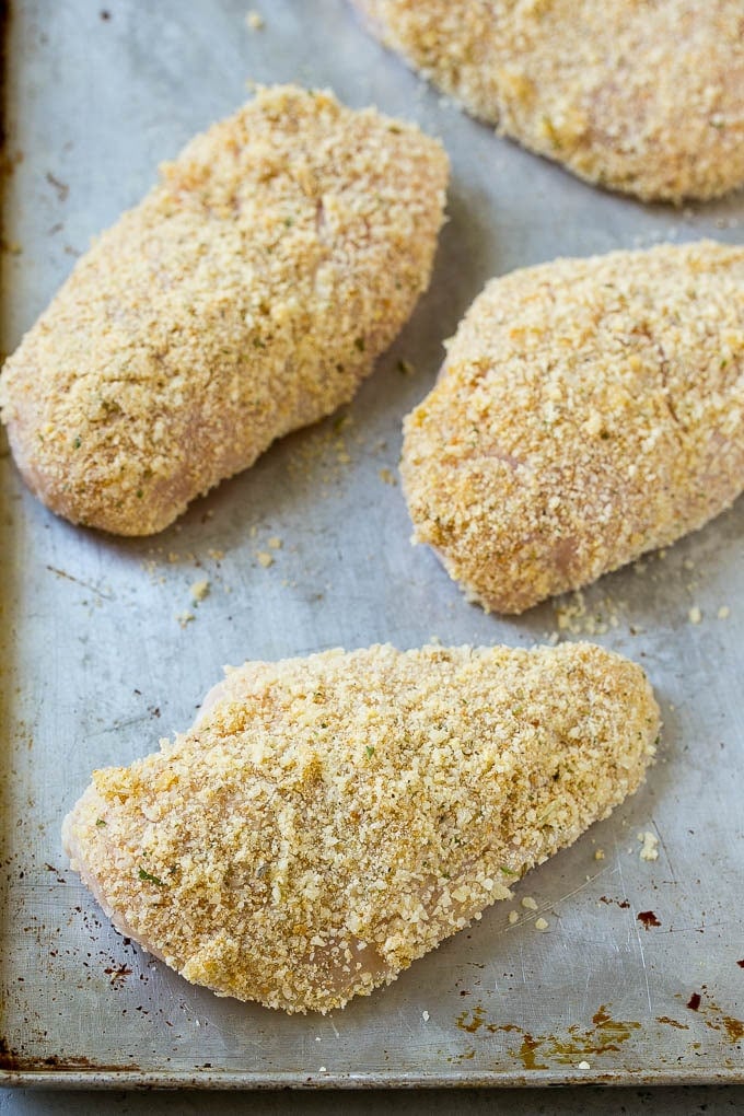Breaded chicken breasts on a sheet pan.