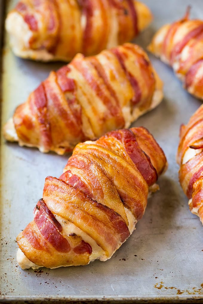 Bacon wrapped chicken breasts on a sheet pan.