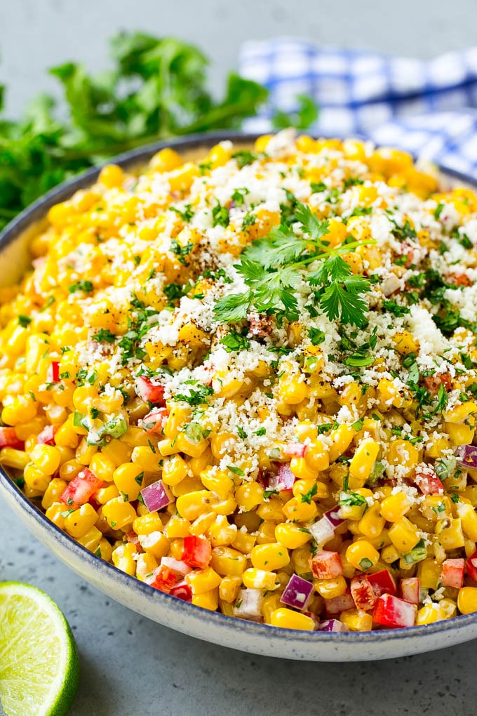 A bowl of Mexican corn salad topped with cotija cheese and fresh cilantro.