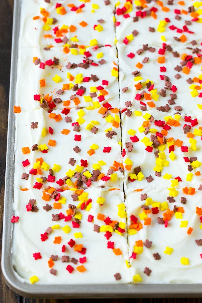 A pan of pumpkin bars with cream cheese frosting and sprinkles.