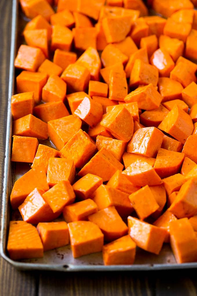 Raw diced sweet potatoes on a sheet pan, ready to go into the oven.