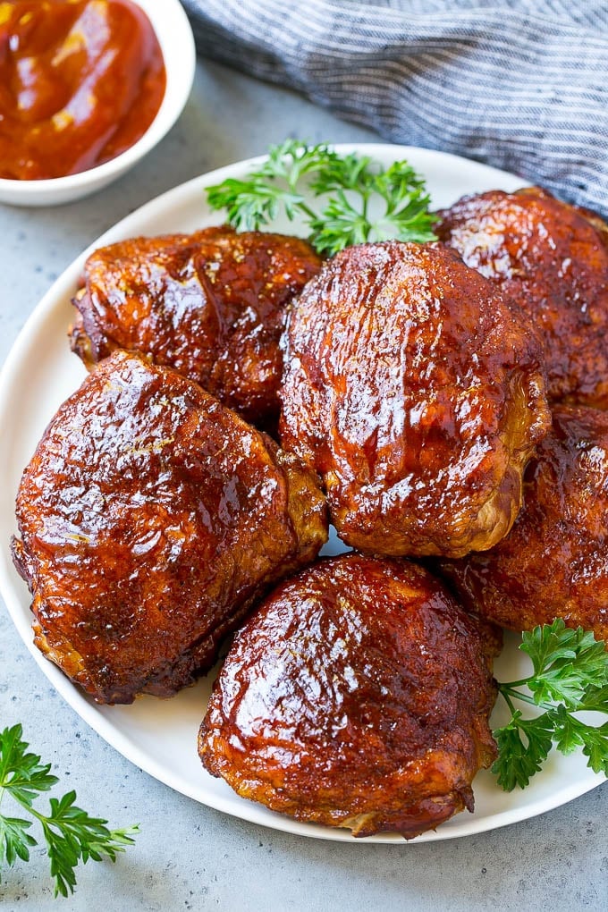 A plate of smoked chicken thighs coated in spice rub and barbecue sauce.
