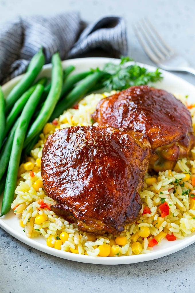 A serving of smoked chicken thighs served with rice and green beans.