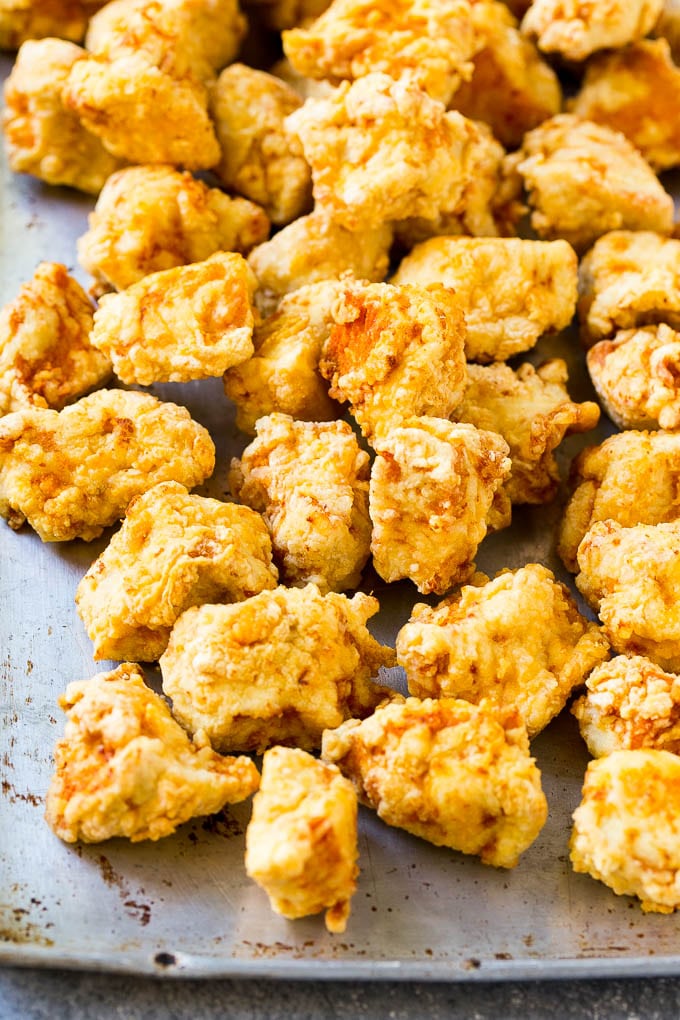 Fried chicken breast pieces on a sheet pan.