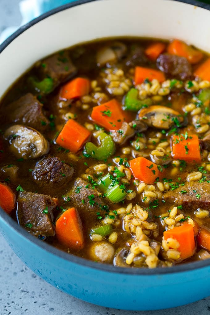 A pot of beef barley soup with mushrooms, carrots and celery.