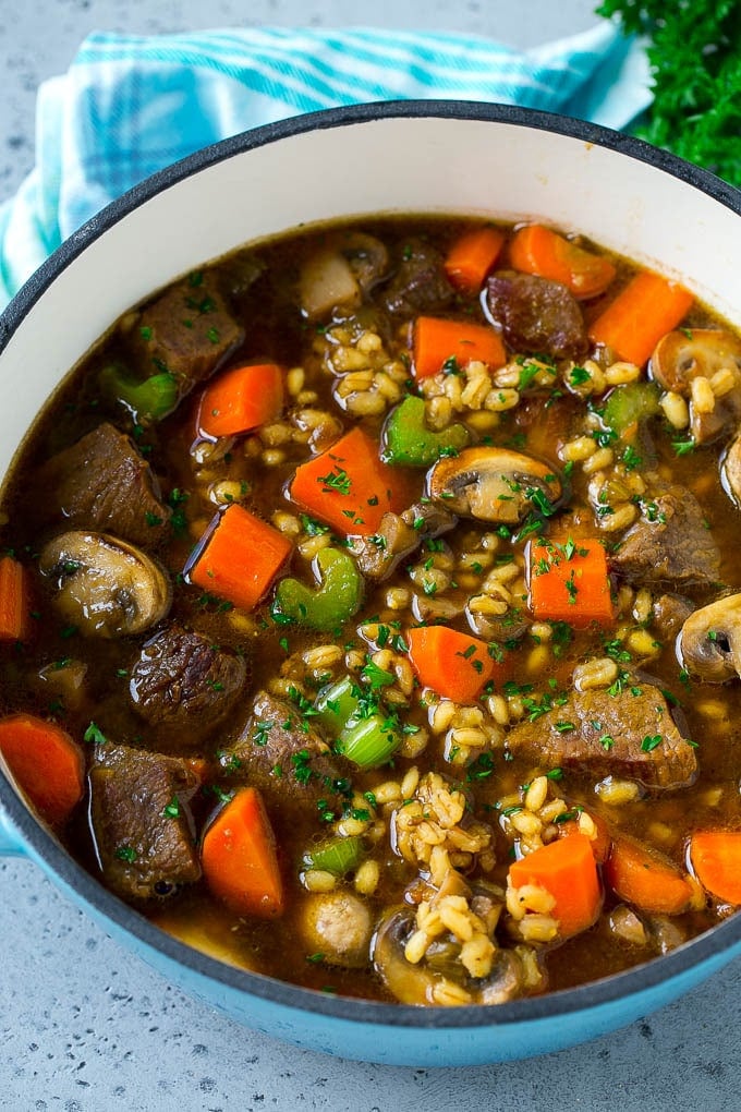 A pot full of beef barley soup made with beef stew meat, barley and vegetables all simmered together.