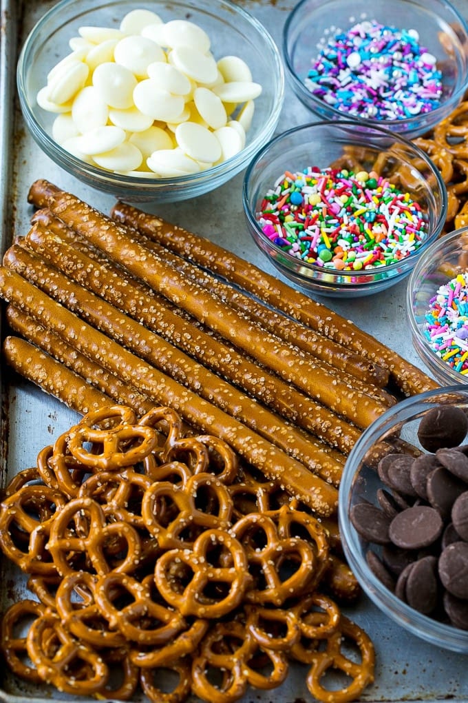 Pretzel twists, pretzel rods, candy melts and sprinkles on a sheet pan.