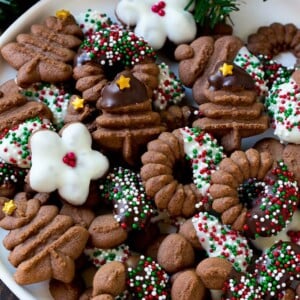 A plate of chocolate spritz cookies decorated with chocolate and sprinkles.
