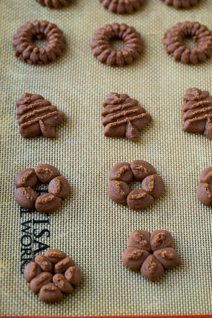 Chocolate spritz cookie dough on a baking sheet.