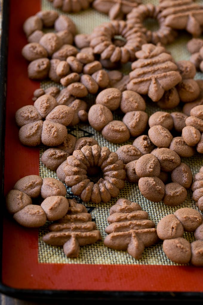 Baked chocolate spritz cookies on a sheet pan.