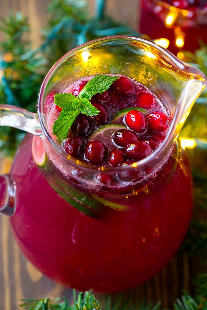 A pitcher of Christmas punch made with pomegranate, lime and cranberry juices.