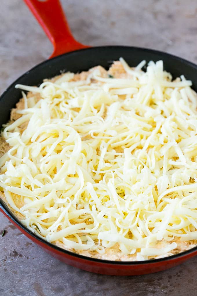 Shredded Monterey Jack cheese sprinkled over a skillet of mixture.