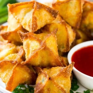 A pile of crab rangoon wontons filled with a creamy crab mixture.