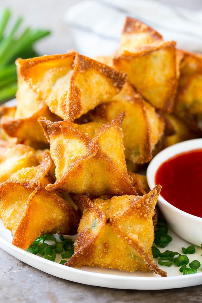 A pile of crab rangoon wontons filled with a creamy crab mixture.