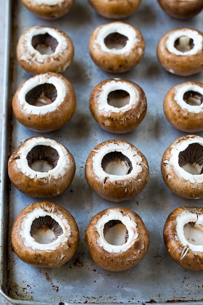 Cremini mushroom caps on a sheet pan.