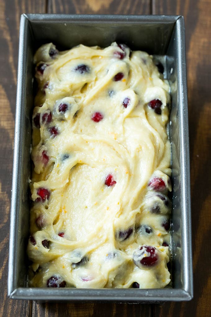 Ccranberry bread batter spread into a loaf pan.