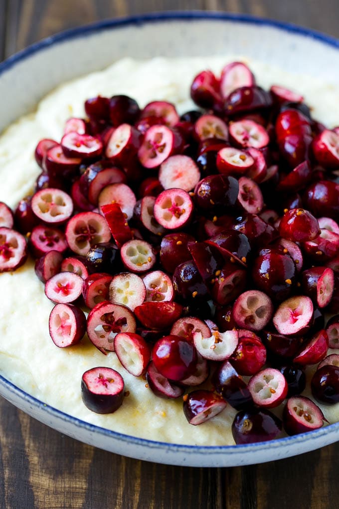 Muffin batter with a pile of chopped cranberries on top.