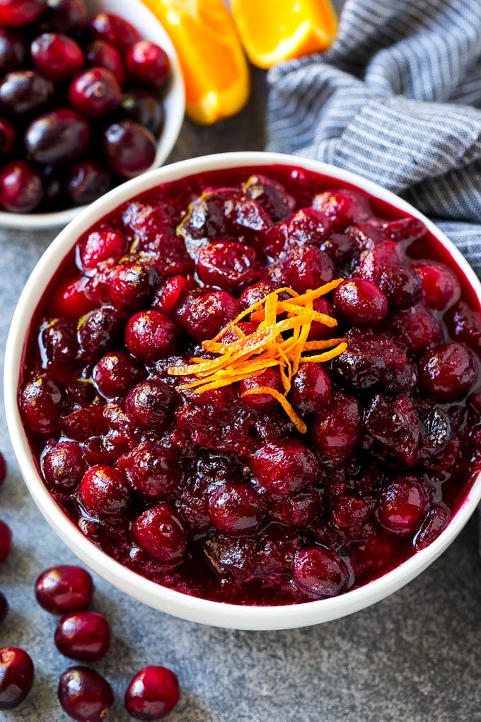 Cranberry orange sauce, topped with fresh orange zest in a serving bowl.