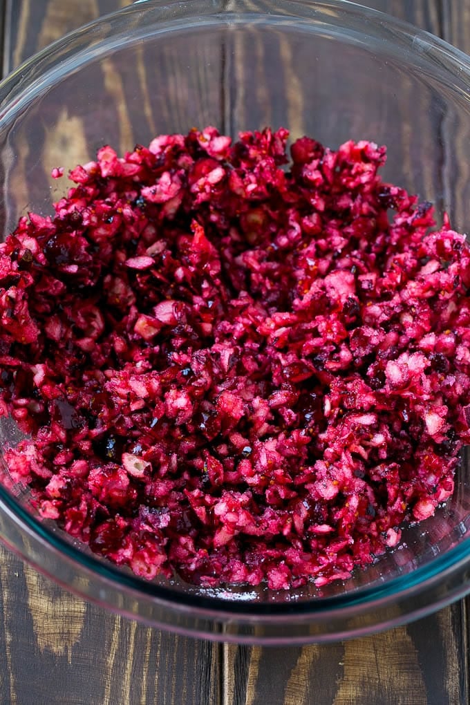 Chopped cranberries mixed with sugar in a bowl.