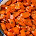 A skillet of glazed carrots with brown sugar and butter sauce.