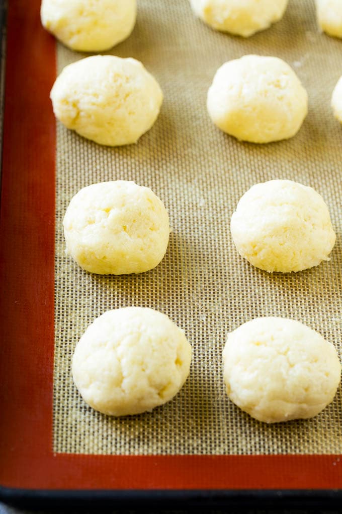 Balls of gooey butter cookie dough on a baking sheet.